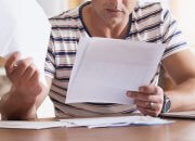 Man filling out and reviewing paperwork
